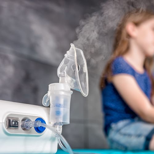 nebulizer with young girl in background