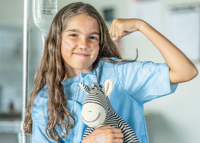 little girl flexing her biceps with oxygen